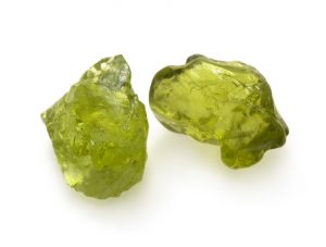 Green peridot raw gemstones on the white background.